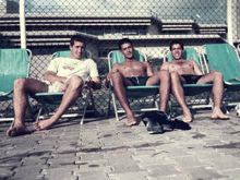 three men are sitting in green chairs with one wearing a shirt that says ' coca-cola ' on it