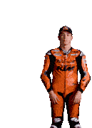 a man wearing a ktm motorcycle suit stands with his hands in his pockets