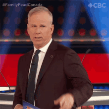 a man in a suit and tie is giving a speech at a podium with a cbc logo in the background