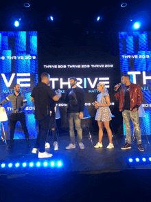 a group of people standing on a stage in front of a sign that says thrive 2019