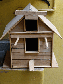 a small wooden birdhouse with a roof and a door