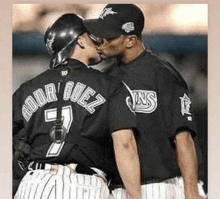 a couple of baseball players are kissing and one of them has the name rodriguez on the back of his shirt