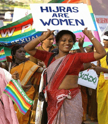 a woman holds up a sign that reads hijras are women