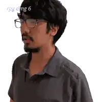 a pixelated image of a man wearing glasses and a shirt with the number 6 visible