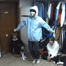 a man in a blue hoodie with a mask on his face is dancing