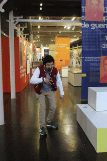 a man in a red jacket is standing in front of a sign that says " l' ecole de gaulle "