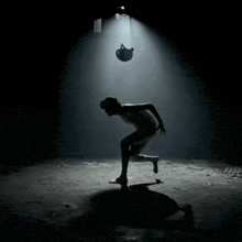 a silhouette of a person in a dark room reaching for something