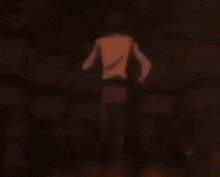 a man without a shirt is standing in a dark room with a sword in his hand .