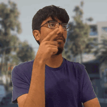 a man wearing glasses and a purple shirt is making a funny face