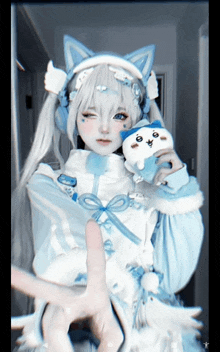 a girl with white hair and blue ears holds a stuffed animal