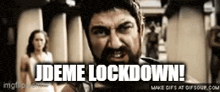 a man with a beard is standing in front of a sign that says jdeme lockdown !