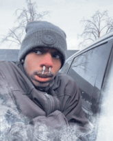 a man wearing a beanie has ice coming out of his nose and mouth