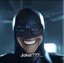 a man in a batman costume is smiling and says `` joker ? '' .