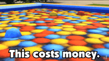 a pool of colorful balls with the words this costs money