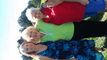 three women posing for a picture with one wearing a red shirt