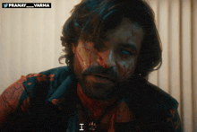 a man with blood on his face has the word i on his neck