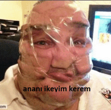 a man with duct tape on his face is sitting in front of a television .