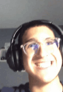 a man wearing headphones and glasses is smiling for the camera