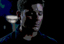 a close up of a man 's face in the dark with a blue background