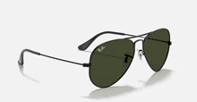 a pair of ray-ban sunglasses with a black frame and green lenses .