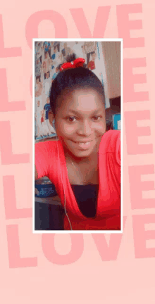 a girl in a red shirt is smiling in front of a pink background that says love