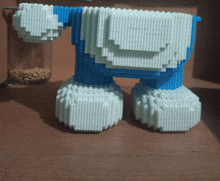 a blue and white toy is sitting on a table next to a glass