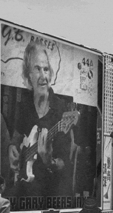 a black and white photo of a man playing a bass guitar under a sign that says gary beers