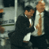 a man in a suit and tie is dancing in front of a sign that says ice