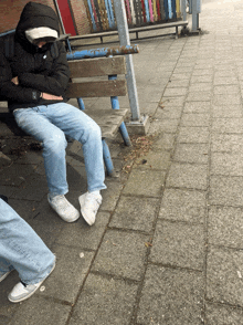 a person sitting on a bench with a nike logo on the back of their jacket