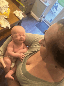 a woman is holding a baby who is crying