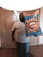 a man holding a bag of cheetos jumbo chips