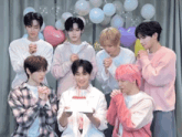 a group of young men are celebrating a birthday with balloons