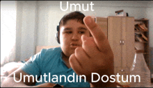 a boy wearing headphones is giving the middle finger with umut written on the bottom