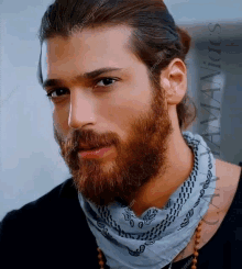 a man with a beard wearing a bandana and a black shirt