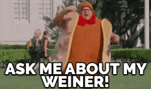 a man in a hot dog costume is saying ask me about my weiner .