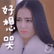 a woman with long black hair is wearing a fur coat and making a sad face .