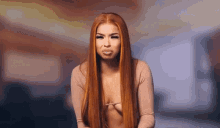 a woman with long red hair is wearing a very revealing top and making a face .