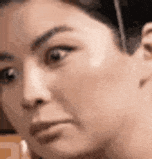 a close up of a woman 's face with a slight smile on her face .