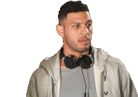 a man wearing headphones and a grey hoodie with the letter u on the front