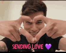 a man is making a heart shape with his hands and the words sending love are on the bottom