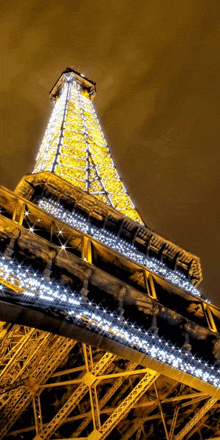 the eiffel tower is lit up at night with lots of lights on it