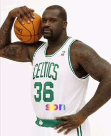 a man in a celtics jersey is holding a basketball