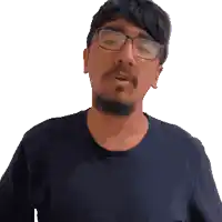 a man with glasses and a beard looks at the camera