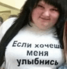 a woman wearing a white t-shirt with russian writing on it .