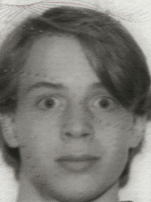 a close up of a young man 's face with a surprised look on his face