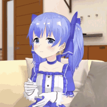 a girl with blue hair is sitting on a couch with her hands folded