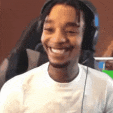a man wearing headphones is smiling and looking at the camera .