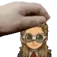 a hand is holding a cartoon character 's head with glasses .