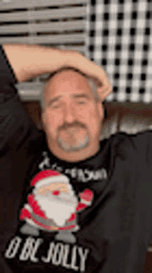 a man wearing a christmas sweater is laying on a couch .