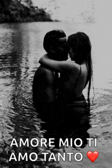 a black and white photo of a man and woman kissing in the water with amore mio ti amo tanto